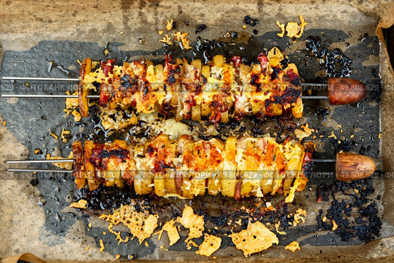 Skewers with fried young potatoes with bacon and cheese, picnic, kebab in roasting tray.. Delicious kebab of bacon and potatoes. Стоковое фото, агентство Ingram Publishing / Фотобанк Лори