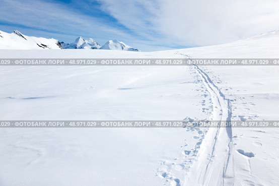 Ski tracks on the fresh snow of a large glacier. In background with the peaks of Monte Rosa massif - Zermatt, Switzerland, Europe. Стоковое фото, агентство Ingram Publishing / Фотобанк Лори