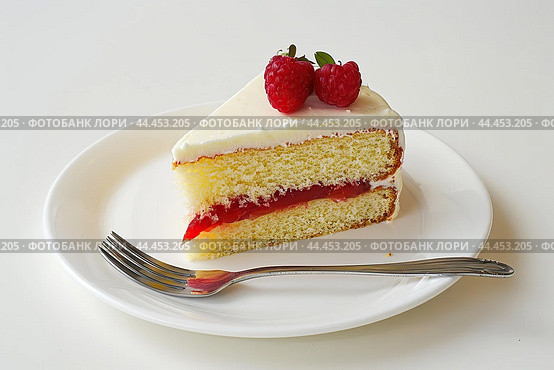 Slice of Victoria sponge cake on a porcelain plate with fork on a white table. Scrumptious biscuit cake with whipped cream and jam decorated of icing sugar, strawberry. Soft light. Copy space for text. Стоковое AI-изображение, AI-художник Марина Демидюк / Фотобанк Лори