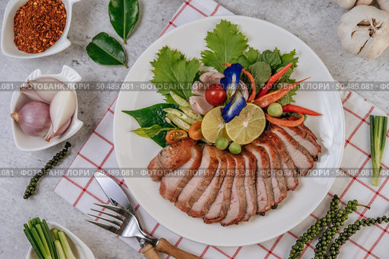 Sliced ??fried pork with lemon, onion, red onion, tomato, long bean, butterfly pea flower, and mint. Стоковое фото, агентство Ingram Publishing / Фотобанк Лори