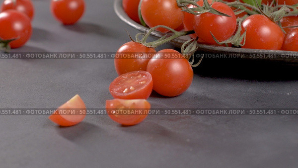 Small red cherry tomatoes on rustic background. Cherry tomatoes on the vine. Стоковое фото, агентство Ingram Publishing / Фотобанк Лори