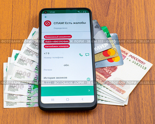 Смартфон с открытым приложением защиты от спама и мошенников на банковских картах и денежных купюрах (2022 год). Редакционное фото, фотограф Анна Аникова / Фотобанк Лори