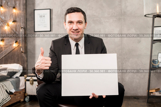 smiling businessman holding blank paper gesturing thumb up. Стоковое фото, агентство Ingram Publishing / Фотобанк Лори