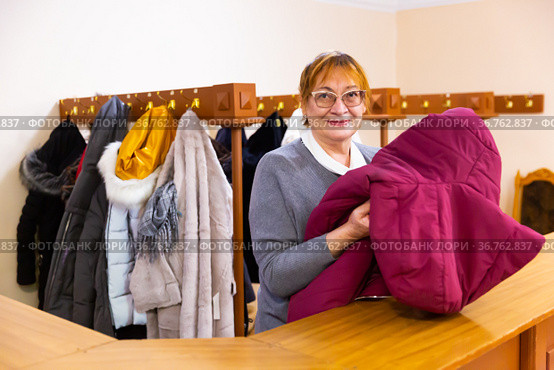 Smiling elderly woman checkroom attendant working in theater. Стоковое фото, фотограф Яков Филимонов / Фотобанк Лори