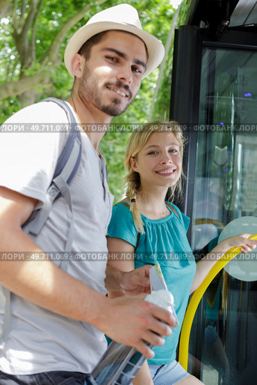 smiling young couple holding hands and entering city bus. Стоковое фото, агентство Ingram Publishing / Фотобанк Лори