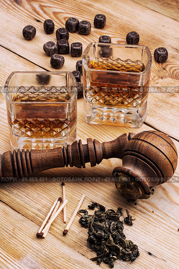 Smoking pipe in a retro style,dark chocolate and glasses of whiskey on wooden background. Smoking pipe. Стоковое фото, агентство Ingram Publishing / Фотобанк Лори