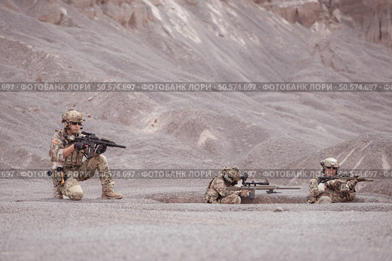 Soldiers in camouflage military uniforms carrying weapons, Reconnaissance missions in rugged mountains, Assault infantry battle training. Стоковое фото, агентство Ingram Publishing / Фотобанк Лори