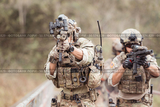 Soldiers in camouflage military uniforms carrying weapons, Reconnaissance missions in the tropical forest area, Assault infantry battle training. Стоковое фото, агентство Ingram Publishing / Фотобанк Лори