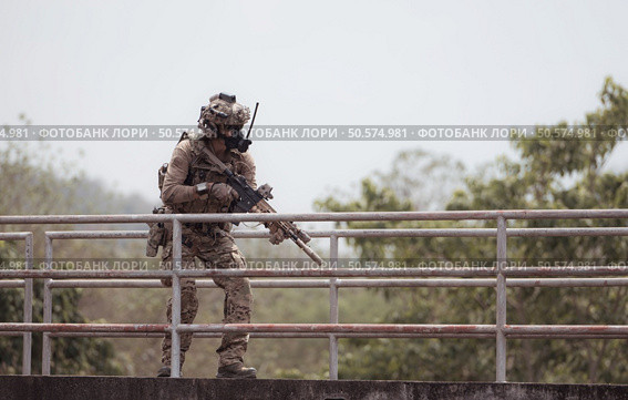 Soldiers in camouflage military uniforms carrying weapons, Reconnaissance missions in the tropical forest area, Assault infantry battle training. Стоковое фото, агентство Ingram Publishing / Фотобанк Лори