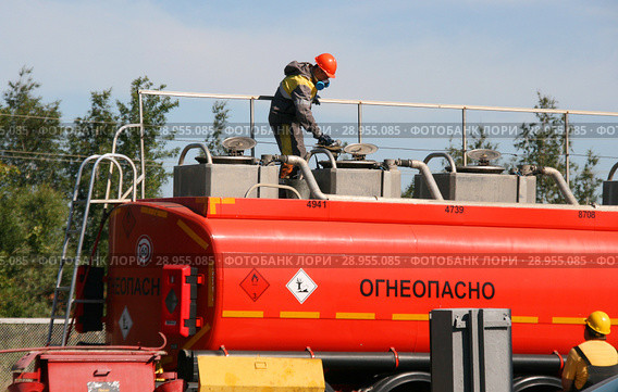 Сотрудник АЗС работает наверху бензовоза. Прием топлива (2018 год). Редакционное фото, фотограф Щеголева Ольга / Фотобанк Лори