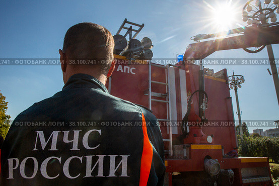 Сотрудник МЧС России стоит у машины во время показательного смотра пожарной техники на ВДНХ в городе Москве, Россия (2022 год). Редакционное фото, фотограф Николай Винокуров / Фотобанк Лори