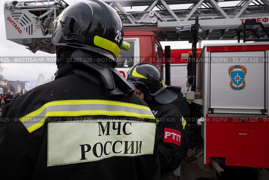 Сотрудники пожарного расчета стоит у пожарной машины во время показательного смотра пожарной техники в честь 30 летия МЧС на ВДНХ в городе Москве, Россия (2020 год). Редакционное фото, фотограф Николай Винокуров / Фотобанк Лори