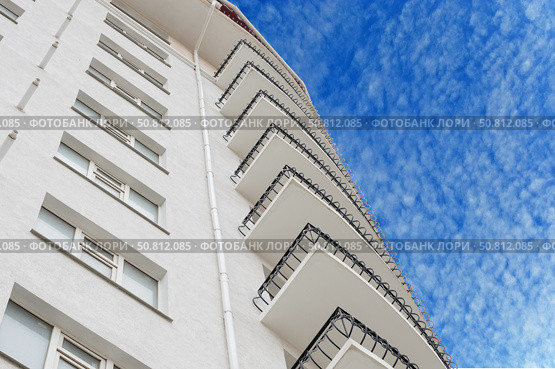 Современный многоэтажный красивый дом на фоне голубого неба. Modern panel apartment building on background of blue sky. Стоковое фото, фотограф Татьяна Д / Фотобанк Лори