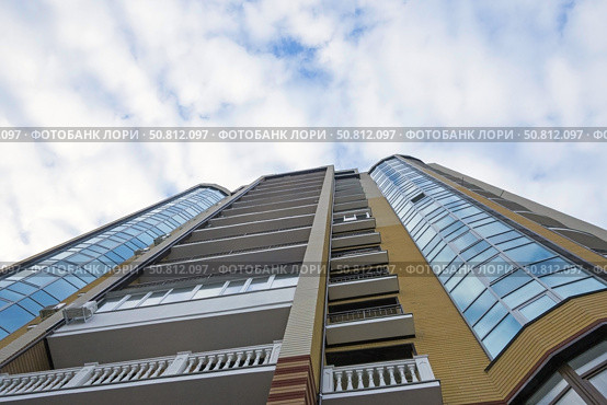 Современный многоэтажный красивый дом на фоне голубого неба. Modern panel apartment building on background of blue sky. Стоковое фото, фотограф Татьяна Д / Фотобанк Лори
