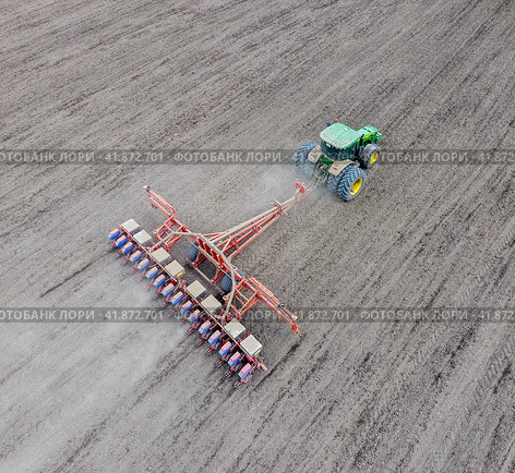 Sowing of corn. Tractor with a seeder on the field. Using a seeder for planting corn. Стоковое фото, фотограф Леонид Еремейчук / Фотобанк Лори