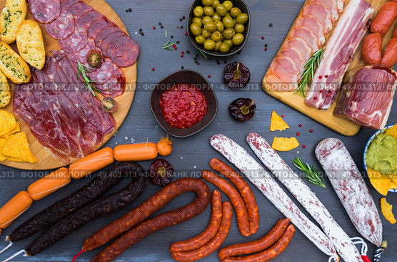 spanish tapas with salami, chorizo, lomo, jamon with red hot salsa sause and olives, picnic table, top view. Picnic table with spanish sausage tapas. Стоковое фото, агентство Ingram Publishing / Фотобанк Лори