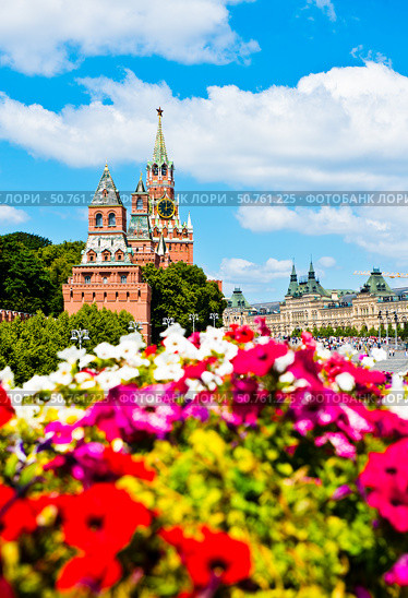 Спасская башня Московского Кремля и яркие красные цветы в солнечный летний день. Москва. Россия. Редакционное фото, фотограф E. O. / Фотобанк Лори