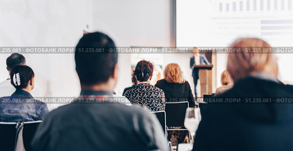 Speaker giving a talk in conference hall at business event. Rear view of unrecognizable people in audience at the conference hall. Business and entrepreneurship concept. Стоковое фото, фотограф Matej Kastelic / Фотобанк Лори