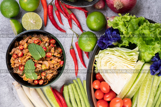 Spicy pork chops in a black cup consisting of lemons Chili and side dishes. Selective focus. Стоковое фото, агентство Ingram Publishing / Фотобанк Лори