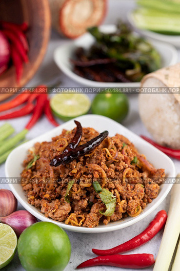 Spicy pork chops in a white dish consisting of lemons, chilies, and side dishes. Selective focus. Стоковое фото, агентство Ingram Publishing / Фотобанк Лори