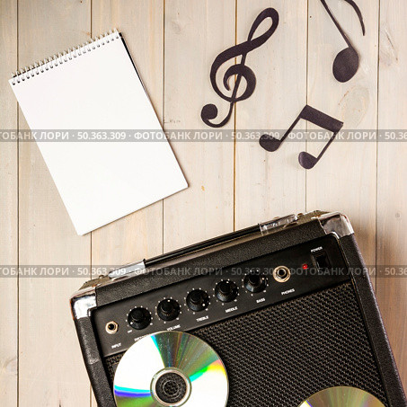 spiral notepad musical note amplifier with compact disc wooden desk. Стоковое фото, агентство Ingram Publishing / Фотобанк Лори