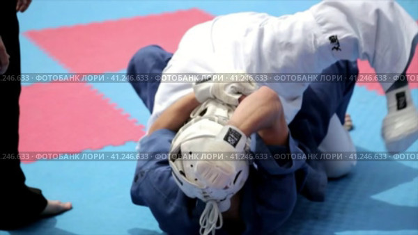 Sports wrestling. Athletes in kimonos and protective helmets on the tatami.  Спортивная борьба. Спортсмены в кимоно и защитных шлемах на татами. (2016 год). Стоковое видео, видеограф Egor Sarantstv / Фотобанк Лори