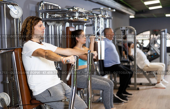 Sporty man doing chest press on execise machine in gym. Стоковое фото, фотограф Яков Филимонов / Фотобанк Лори