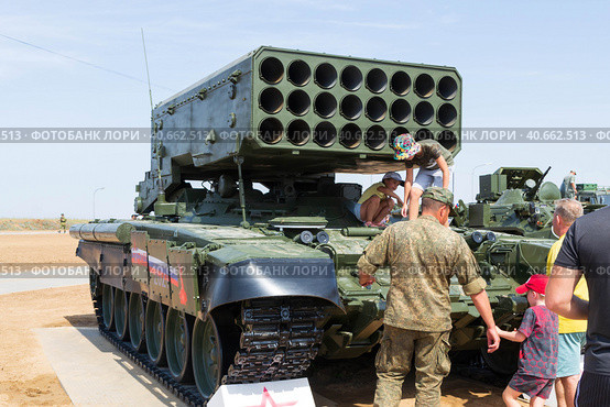 Средняя Ахтуба, Волгоградская область, Россия. Военная техника. Тяжелая огнемётная система ТОС-1А «Солнцепёк» на танковом шасси в парке «Патриот», люди интересуются военной техникой. (2021 год). Редакционное фото, фотограф Андрей Цыганков / Фотобанк Лори