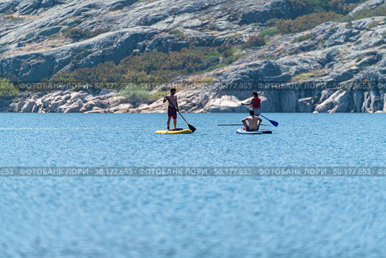 Stand up paddleboarding on lake. Watersport on lake. Tourist outdoor activity at Lagoa Comprida, Serra da Estrela National Park in Portugal. Стоковое фото, агентство Ingram Publishing / Фотобанк Лори