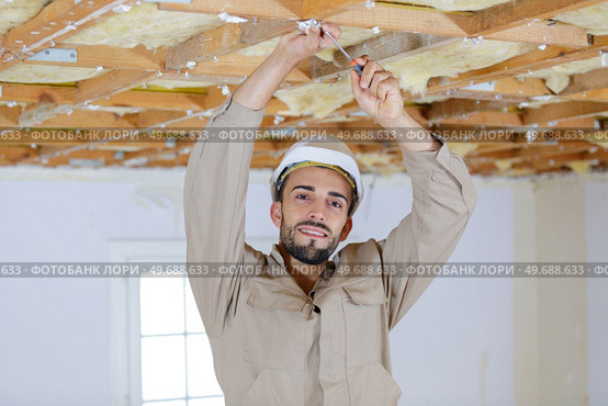 standing on a scaffold to reach the ceiling. Стоковое фото, агентство Ingram Publishing / Фотобанк Лори