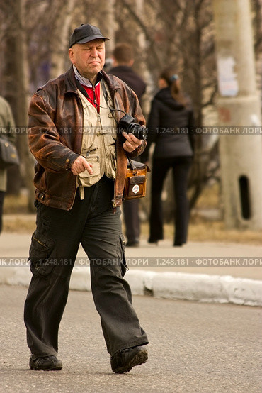 Старый фотограф идущий по улице (2009 год). Редакционное фото, фотограф Михаил Митин / Фотобанк Лори
