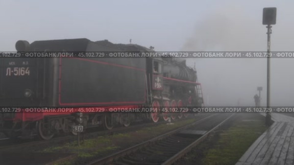 Старый советский паровоз серии "Л" двигается задним ходом туманным октябрьским утром. Станция Сортавала. Редакционное видео, видеограф Виктор Карасев / Фотобанк Лори