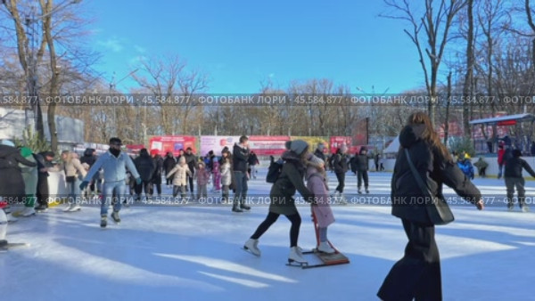 Ставрополь, парк Победы - Люди катаются на коньках на открытом катке в городском парке. Зимний городской пейзаж с толпой людей на открытом катке. Новогодние и Рождественские каникулы. Редакционное видео, видеограф Ирина Михайличенко / Фотобанк Лори