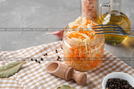 Стеклянная банка с домашней квашеной капустой, приправами и маслом на сером фоне. Крупный план. Стоковое фото, фотограф Pixel_shot / Фотобанк Лори