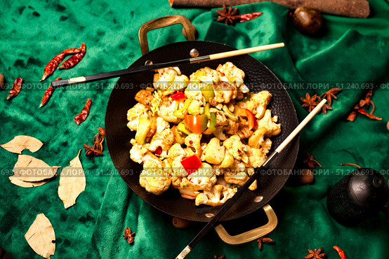 Stir-fried Cauliflower Delight in a Wok, Oriental Spices on a Green Velvet. Стоковое фото, фотограф Aleksandr Golubev / Фотобанк Лори