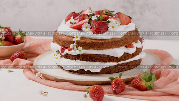 Strawberry cake, strawberry sponge cake with fresh strawberries and sour cream on a kitchen countertop. Стоковое фото, агентство Ingram Publishing / Фотобанк Лори