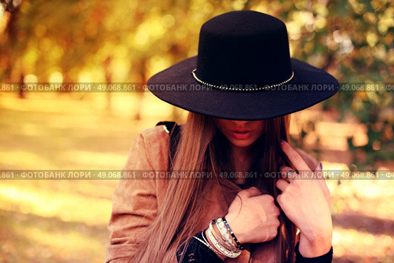 Street fashion concept - closeup portrait of a pretty girl. Wearing hat and suede jacket holding bag with fringe. Beautiful autumn woman. . Стоковое фото, агентство Ingram Publishing / Фотобанк Лори