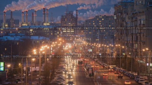 Street lights illuminating urban roadside with moving and parked vehicles, industrial chimneys releasing smoke against dusky sky in winter moscow cityscape. Стоковое AI-видео, аниматор Юрий Поздников / Фотобанк Лори