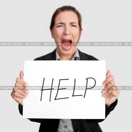Stressed business woman imploring for help, holding a cardboard with the message "Help". Focus is on the cardboard. Стоковое фото, агентство Ingram Publishing / Фотобанк Лори