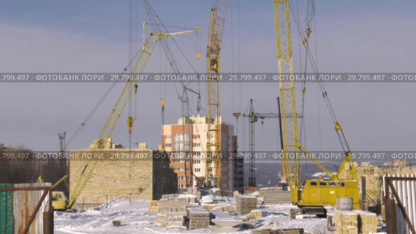 Строительство многоэтажного здания зимой. 2 плана. Construction of a multi-storey building in winter. 2 shots. (2019 год). Редакционное видео, видеограф Евгений Романов / Фотобанк Лори