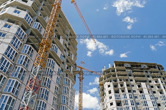 Строящееся высотное здание и подъемный кран на фоне голубого неба. Building crane and building under construction against blue sky. Стоковое фото, фотограф Татьяна Д / Фотобанк Лори