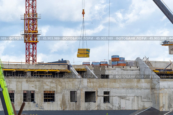 Строящееся высотное здание и подъемный кран на фоне голубого неба. Building crane and building under construction against blue sky. Стоковое фото, фотограф Татьяна Д / Фотобанк Лори