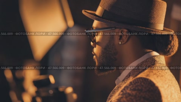Stylish musician posing for photoshoot with softboxes. Стоковое AI-видео, аниматор Юрий Поздников / Фотобанк Лори