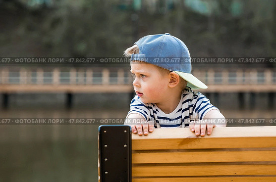 Summer lifestyle. A cute little boy is having fun playing in a modern outdoor playground. The concept of family entertainment and leisure. Стоковое фото, фотограф Photojuli / Фотобанк Лори