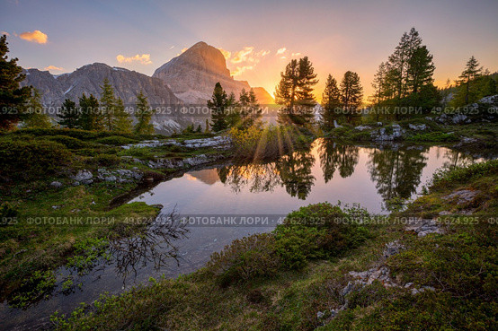 sunrise in summer over pond close to Lago di Limides, Colle Santa Lucia, Dolomites, Italy. sunrise over pond close to Lago di Limides, Dolomites, Italy. Стоковое фото, агентство Ingram Publishing / Фотобанк Лори