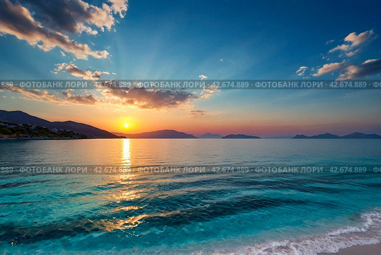 Sunset in laguna of azure Aegean Sea with lush mountains, fluffy clouds, yacht, summer weather. Nature landscape in East Turkey. Concept of vacation, recreation and travel. Стоковое AI-изображение, AI-художник Aleksandr Golubev / Фотобанк Лори