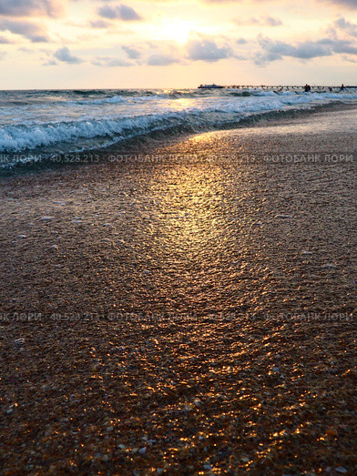 Sunset over sea. Beautiful sunset. Foamy waves roll over the sandy shore. Vityazevo, Anapa, Black Sea. Tourist mecca, health resort. Colorful clouds in the evening sky. Стоковое фото, фотограф Юлия Петровская / Фотобанк Лори