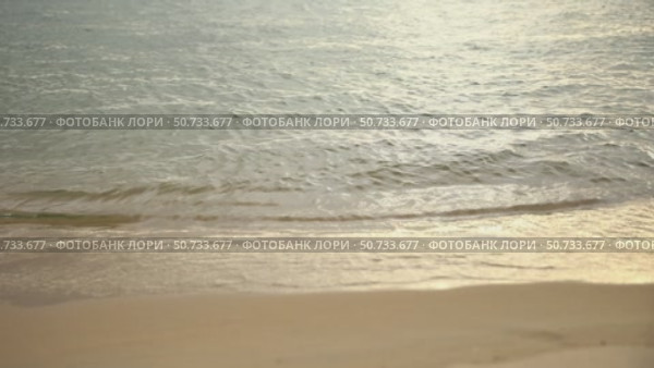 Sunset sandy beach with ocean in the background. Sea waves near the tropical coast on a sunny day. Cruise. Landscape of a summer sea beach with white sand. Slow motion footage. Стоковое видео, видеограф Ирина Михайличенко / Фотобанк Лори
