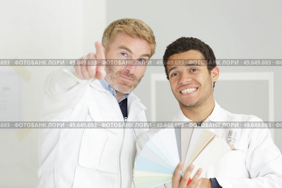 supervisor with apprentice decorator holding colour samples. Стоковое фото, агентство Ingram Publishing / Фотобанк Лори