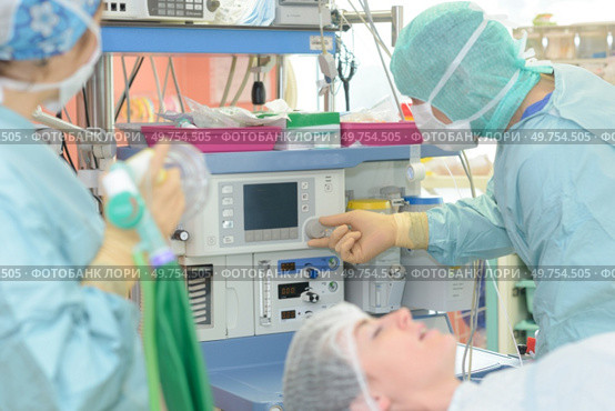 surgeons working with monitoring of patient in surgical operating room. Стоковое фото, агентство Ingram Publishing / Фотобанк Лори